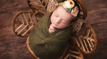 Baby girl in a rattan flower chair