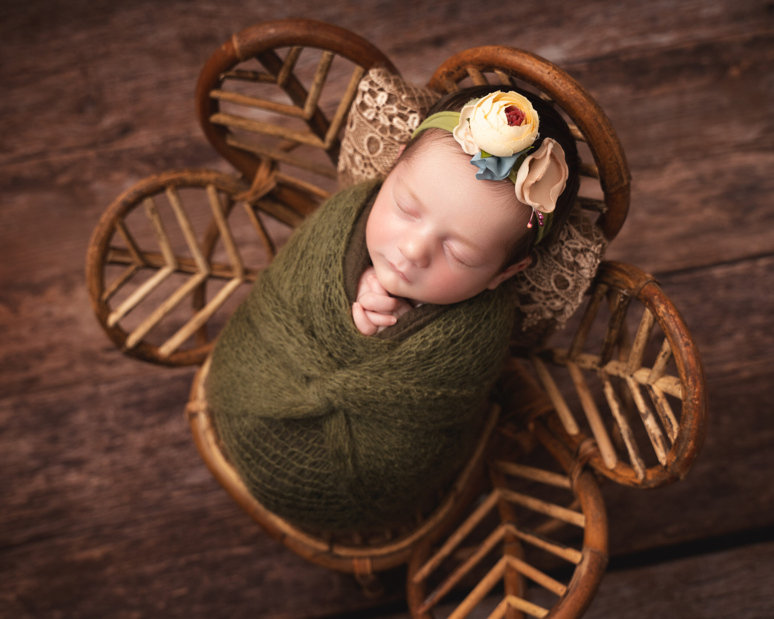 Baby girl in a rattan flower chair