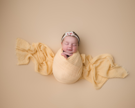 Newborn baby girl in yellow