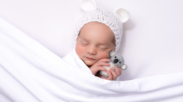 Baby girl in white with toy