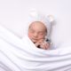 Baby girl in white with toy