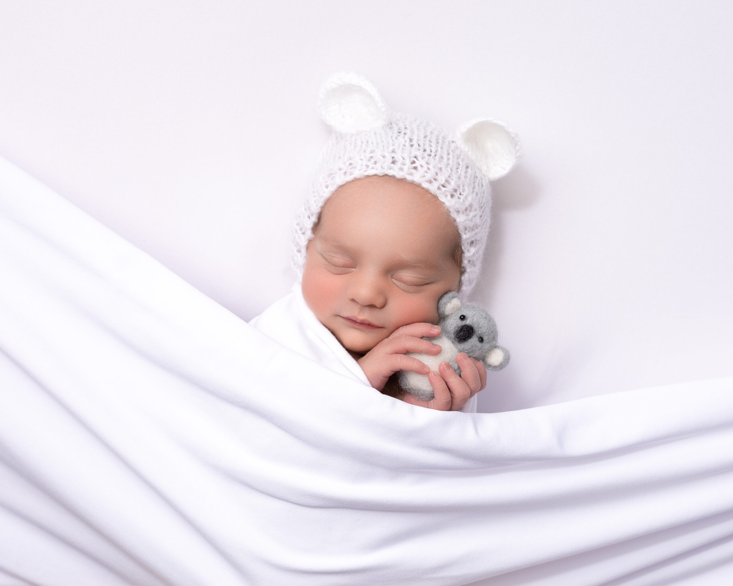 Baby girl in white with toy